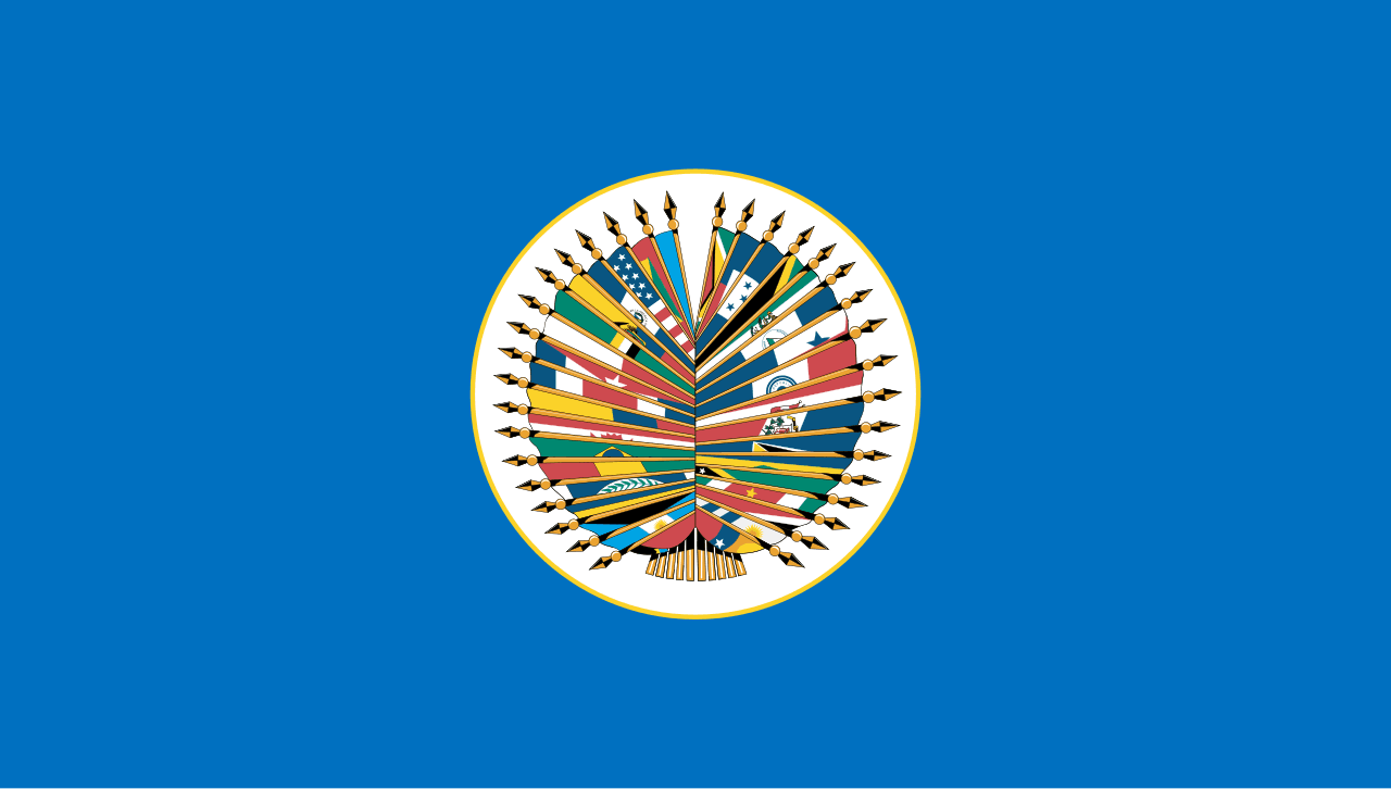 Emblema circular de la Organización de Estados Americanos con las banderas de sus países miembros radiando desde el centro sobre fondo azul.