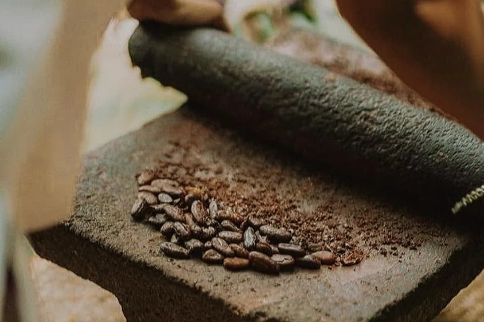 Granos de cacao molidos en metate, tradición del chocolate artesanal de Ah Cacao
